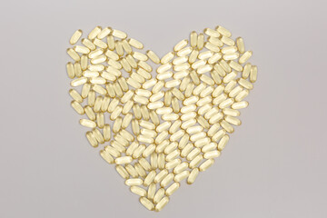 many Omega-3 capsules are laid out in the shape of a heart