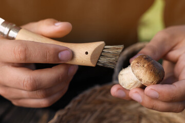 Man cleaning mushroom with brush, closeup view