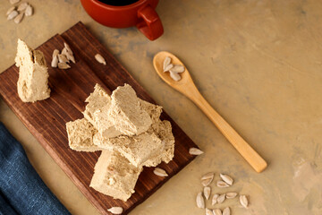 Sunflower halva on a wooden board and a light background with blue textiles. Natural vegan product. Eastern sweetness. Rustic style.