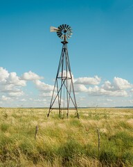A windmill in a grassy field along Route 66 in New Mexico