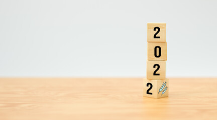 cubes with number 2022 and vaccination symbol on wooden  background