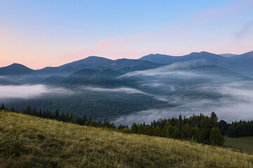 Naklejka na ściany i meble Amazing view of beautiful mountain landscape covered with fog
