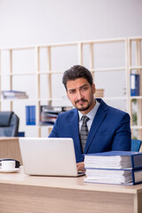 Fototapeta premium Young handsome employee working in the office