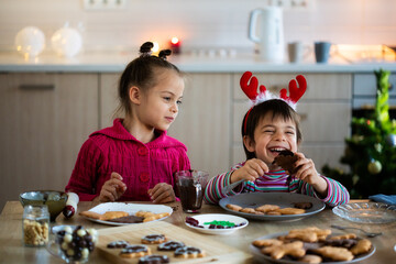 Children decorating Christmas cookies and having fun at home