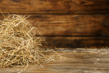 Heap of dried hay on wooden table. Space for text