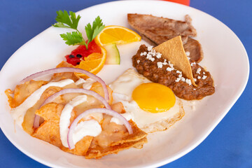 Huevo estrellado con frijoles refritos chilaquiles y fruta