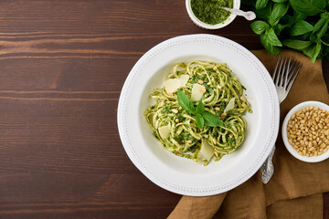 Traditional italian pasta pesto with pine nuts, crushed garlic, basil leaves, parmesan cheese and olive oil. Mediterranean pesto sauce and spaghetti. Delicious vegetarian meal