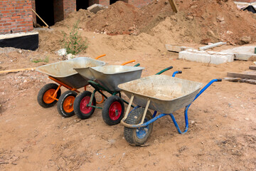 Construction wheelbarrows. Three wheelbarrows without people on the construction site. Construction tool.