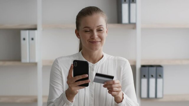 Mobile Banking. Businesswoman Using Credit Card And Smartphone At Workplace In Office