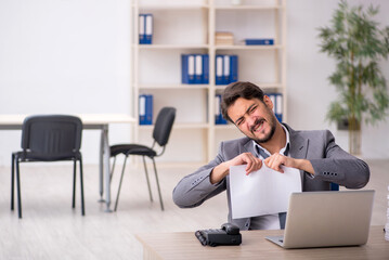 Young male employee and too much work in the office