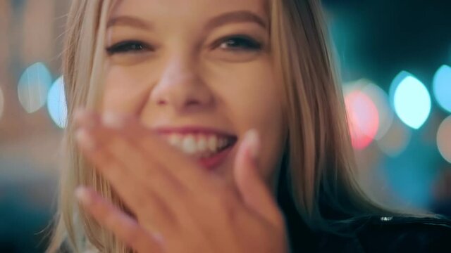 Happy carefree charming student girl having fun, showing tongue out and smiling, behaving in a naughty childish way with positive emotion. Portrait of sexy girl in night city