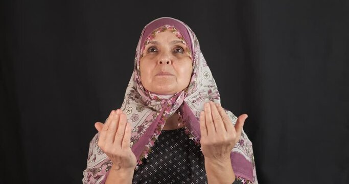 Old, senior muslim woman is praying. Faith and islam concept. Prayer senior Turkish Middle Eastern woman, ramadan concept.