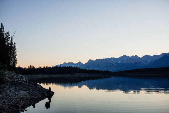 Lake at dawn.  A soft sunrise over a mountain lake with a mirror image in the lake in the Rocky Mountains of Canada