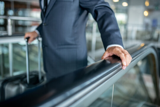 Male hand touching handrail on escalator