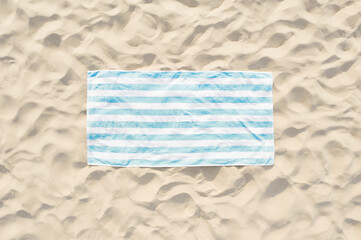 Striped beach towel on sand, aerial view