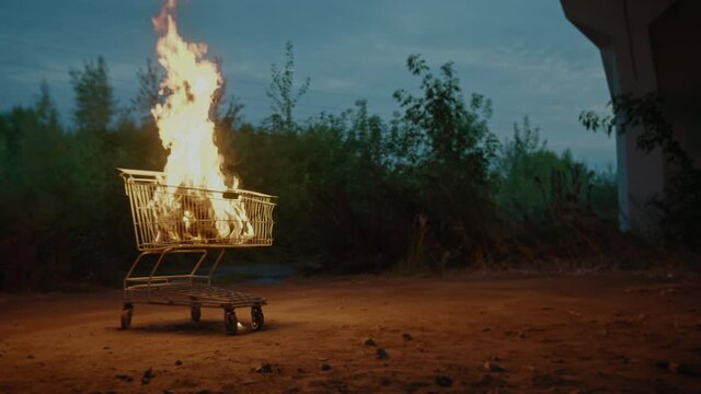 Shopping cart with goods on fire outdoors on black Friday. Best offer and hot discounts on sale, bargain buy
