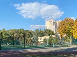 Naklejka premium Scenic autumn in the city. Secondary school and sport stadium in Kiev city, capital of Ukraine. Peaceful cityscape of Kyiv town at autumn sunny day.