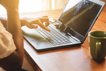 Mujer de negocios de piel morena anónima utilizando la computadora en un plano cerrado 