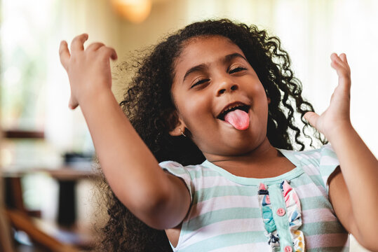 Ni&ntilde;a afroamericana muy feliz haciendo muecas y gestos con las manos