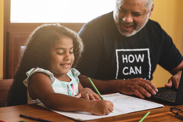 padre e hija sentados haciendo tareas muy felices y disfrutando juntos