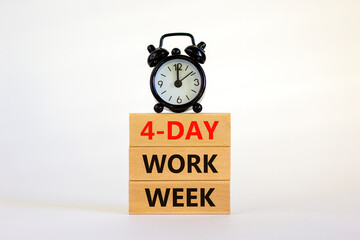 4-day work week symbol. Concept words '4-day work week' on wooden blocks. Black alarm clock. Beautiful white background. Copy space. Business and 4-day work week concept.