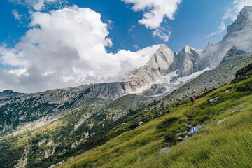 Fototapeta na wymiar Beautiful summer view of Piz Badile (Pizzo Badile), high alpine granit peak in Bregaglia (Bergell) mountain range. High alpine summit, huge rock wall, popular climbing area.