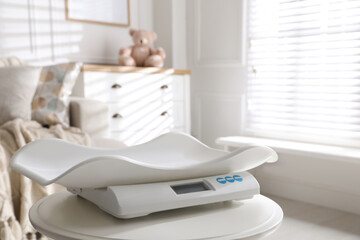 Modern digital baby scales on table in room