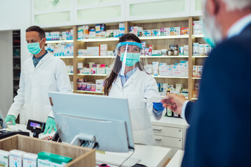 Customer giving prescription for medication to a pharmacist.