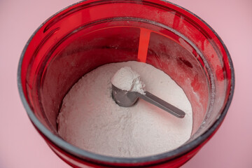 Sports supplement in red tin, creatine, hmb, bcaa, amino acid or vitamin powder. Sports nutrition concept.