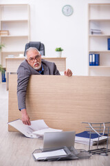 Fototapeta na wymiar Old male employee unhappy with excessive work in the office