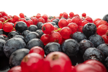 Various fresh wild berries on a black glass background, side view. Berry mix. Lingonberry, strawberry.