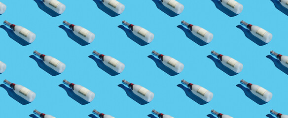 Pattern of champagne bottles on blue pastel background