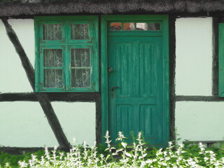 Front starego budynku z zielonymi oknami i drzwiami