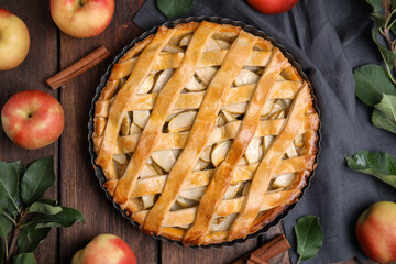 Delicious traditional apple pie on wooden table, flat lay