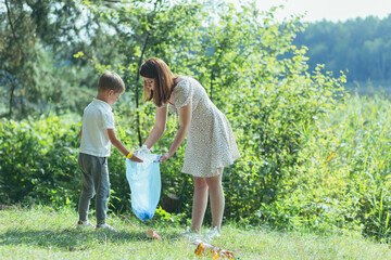 family volunteer cleans garbage in nature. Father and mother, parents, children, son family...