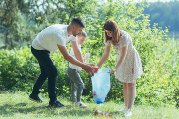 Fototapeta premium family volunteer cleans garbage in nature. Father and mother, parents, children, son family volunteers in a sunny day cleaning up the rubbish waste bottles in forest of debri folding in plastic bag