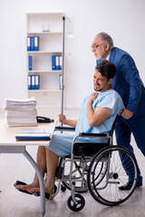 Fototapeta na wymiar Young male employee in wheel-chair feeling bad at workplace