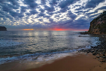 Sunrise at the seaside under a cloud filled sky