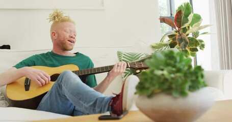 Albino african american man with dreadlocks playing guitars and singing - Powered by Adobe