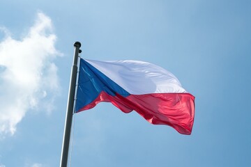 The national flag of the Czech Republic, flying under a blue sky.