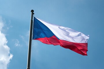 The national flag of the Czech Republic, flying under a blue sky.