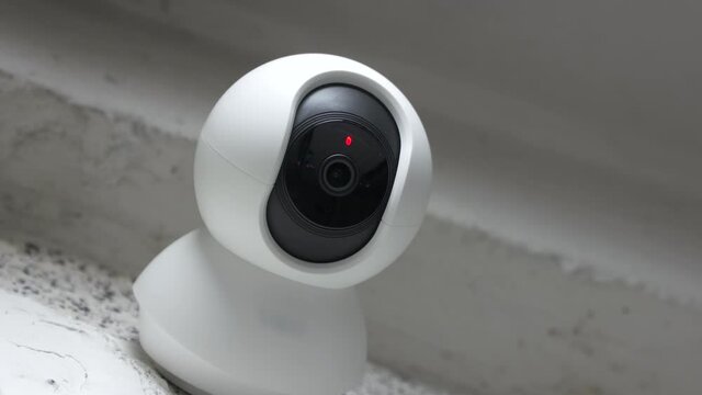 Modern pan tilt home security surveillance Wi-Fi camera on a wall. High quality 4k footage