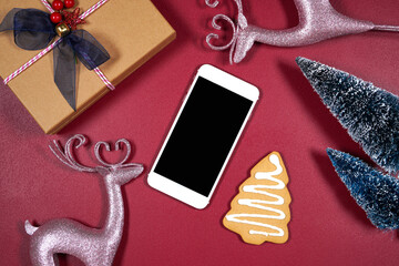 Smart phone product mockup. Christmas theme svg craft product mockup with pink reindeers, gift, gingerbread cookies and Xmas trees against a dark red magenta background.