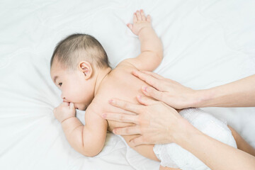 Cute baby massage back in bed, child and health concept.Baby massage and exercises.
