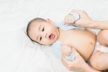 Cute asian happy 5 months baby boy.Mother's hand playing with her son in the bedroom.little kid relaxing at home.Lifestyle.top view. Space for text.