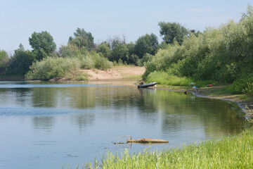 Boat with a motor on the river bank. Fishing in  summer