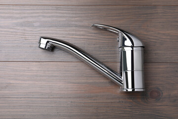Single handle water tap on wooden table, top view