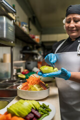 Vertical image of a chef slicing vegetables over his hand with a variety of vegetables on the table