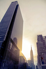 The afternoon sun sets behind the skyscrapers of New York City. Concept business Life