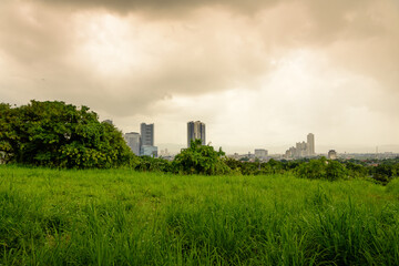 Fototapeta na wymiar Metro Manila skyline as seen from Quezon City with colorful clouds and rain.